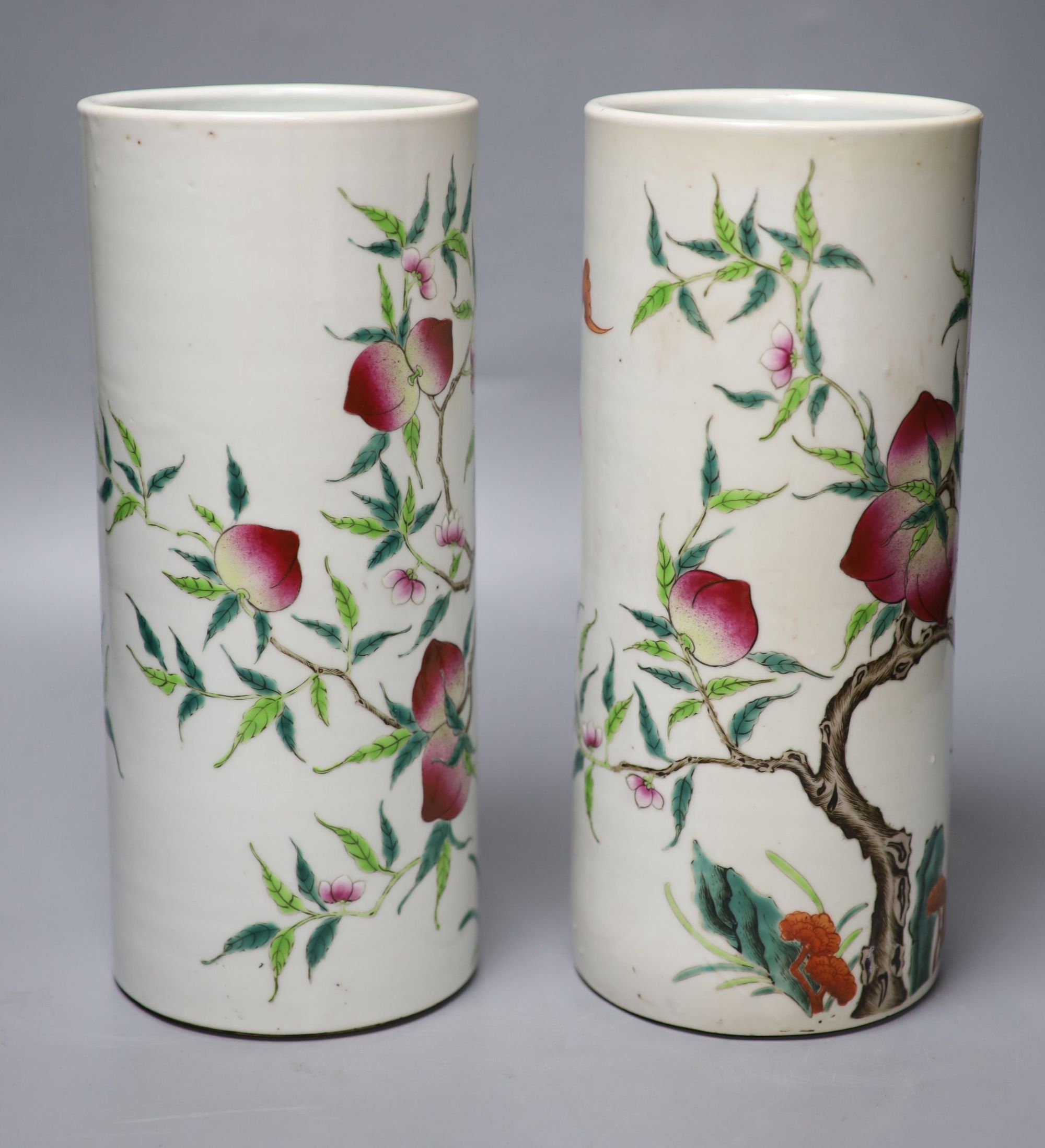 A pair of Chinese famille rose nine peach cylindrical vases, height 28cm